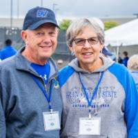 Two alumni from the class of 1968, pose for a photo at the Alumni Homecoming Tailgate.